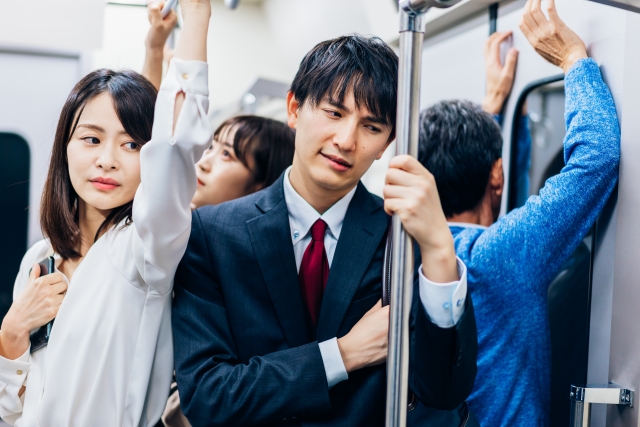 不安そうな顔で電車に乗る男性