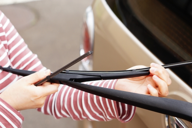 車のワイパーを触る女性