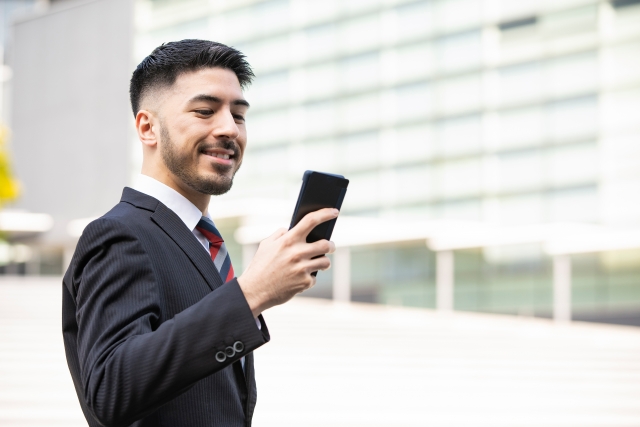 笑顔でスマホを見つめる男性