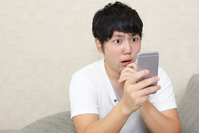 スマホを見て驚愕する男性